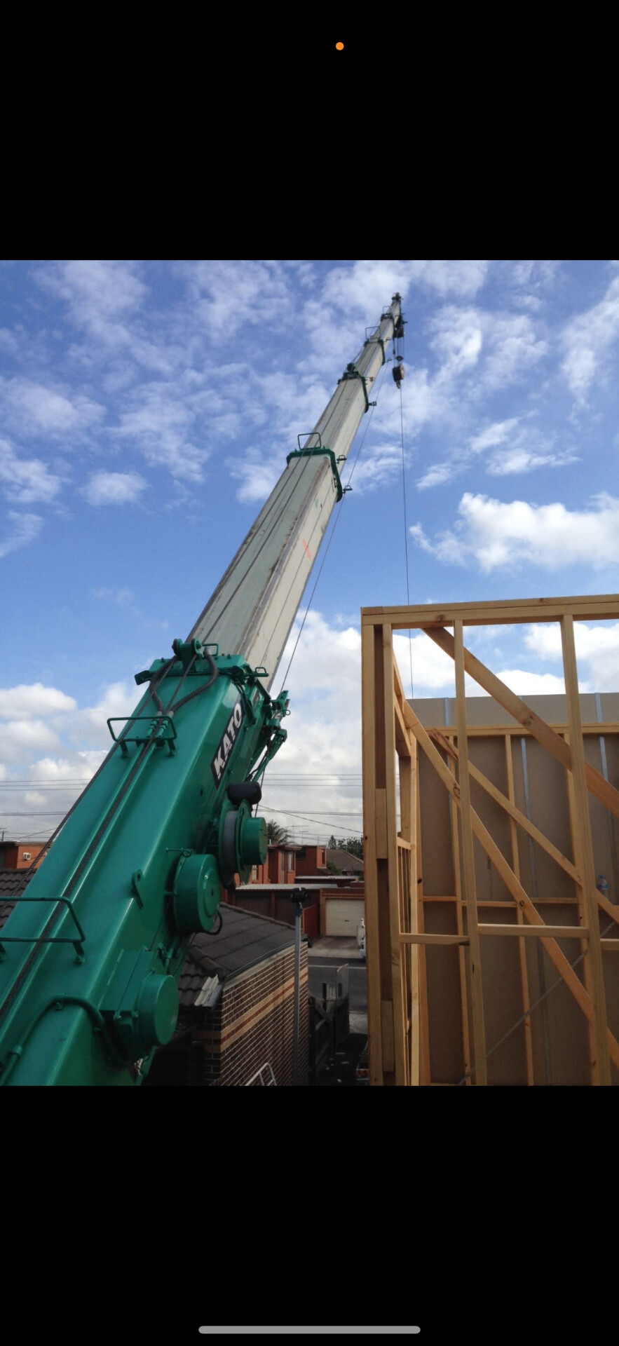 Hudson crane services mobile crane lifting materials onto a timber-framed build
